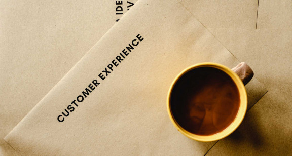 Coffee cup on paper saying "Customer Experience"