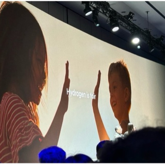 Écran présentant une image de deux enfants qui se tapent  dans la main, accompagnée du texte « Hydrogen is fair »