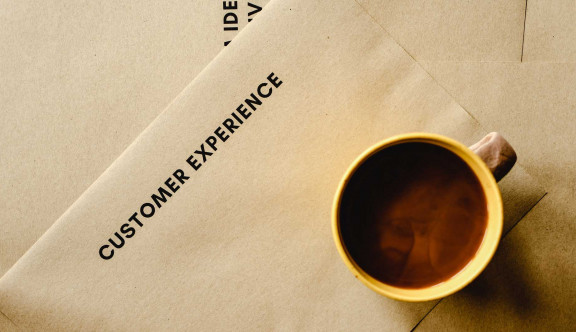 Coffee cup on paper saying "Customer Experience"